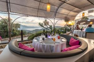 un restaurante con una mesa con sillas rosas y vistas en A Casa Di Mà, en Lumio