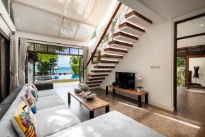 a living room with a couch and a staircase at The Emerald Hill Beach Villa in Mae Nam