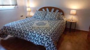 1 dormitorio con 1 cama con edredón azul y blanco en SITO HOME MÁLAGA cerca de Aeropuerto, Playa, Metro, Bus, en Málaga
