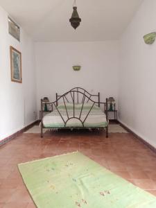 a bed in a room with a rug on the floor at RIAD ACACIA in Essaouira