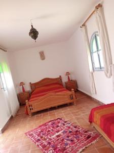 a bedroom with a bed and a rug on the floor at RIAD ACACIA in Essaouira