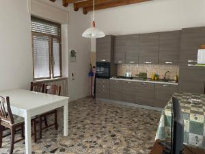 a kitchen with a white table and chairs in a room at Casa Alieta in Torre Lapillo