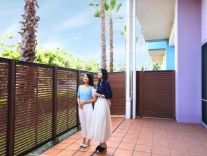 two women standing on a balcony of a house at Mitsui Garden Hotel Prana Tokyo Bay in Urayasu