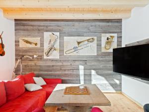 - un salon avec un canapé rouge et un mur en bois dans l'établissement Cozy holiday home with sauna in Sankt Margarethen, à Sankt Margarethen im Lungau