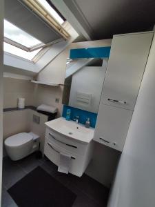 a bathroom with a white sink and a toilet at Duplex Autonome Cosy à Paris Roissy CDG in Roissy-en-France