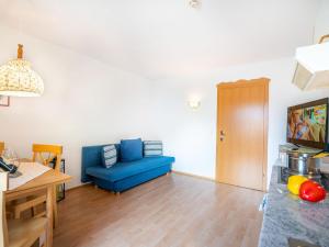 uma sala de estar com um sofá azul e uma mesa em Ideal Apartment in Stubaital with Balcony em Neustift im Stubaital