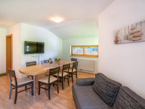 cocina y comedor con mesa y sillas en Spacious Apartment in the Stubaital with Mountain Views, en Neustift im Stubaital