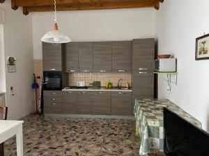 トッレ・ラピッロにあるCasa Alietaの茶色のキャビネットとテーブル付きのキッチンが備わります。