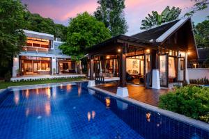 a house with a swimming pool in front of a house at The Emerald Hill Beach Villa in Mae Nam
