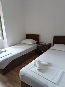 a room with two beds and a table in it at Nova dvokrevetna soba sa dva odvojena kreveta i zajedničkim kupatilom in Kotor +12 photos