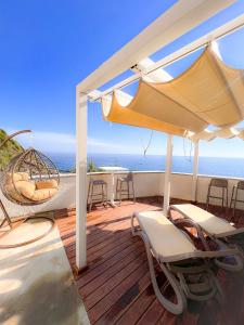 a deck with chairs and a swing and the ocean at La Ripa Camere Vernazza - The Spinnaker Suite in Vernazza