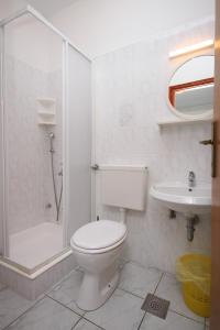 a bathroom with a toilet and a shower and a sink at Apartments by the sea Novalja, Pag - 3307 in Novalja