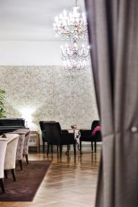 una sala da pranzo con lampadario pendente, tavolo e sedie di Hotel Piccola Vela a Desenzano del Garda