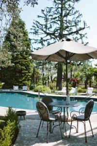 a table and chairs with an umbrella next to a pool at Hotel Piccola Vela in Desenzano del Garda