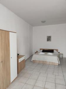 een witte slaapkamer met een bed en een tegelvloer bij Al Ventotto di Maria in Foligno