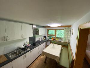 une cuisine avec un évier et une table à l'intérieur dans l'établissement Haus Waldrand, à Oberndorf en Tyrol 23 autres photos