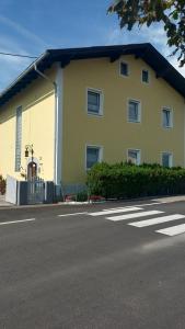 żółty budynek na poboczu ulicy w obiekcie Apartment Monsberger w mieście Wolfsberg