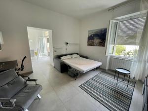 Cette chambre comprend un lit, un canapé et une fenêtre. dans l'établissement Appartamento appena ristrutturato, à Massa