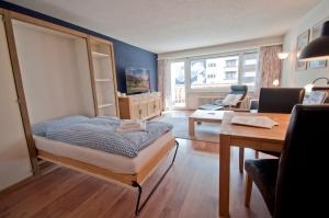 - une chambre avec un lit, un bureau et une table dans l'établissement Haus Viktoria A, Apartment Stockhorn, à Zermatt