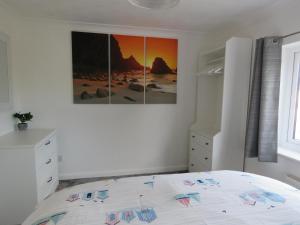 een slaapkamer met een bed en een schilderij aan de muur bij Private 2 bedroom house close to the beach in Paignton