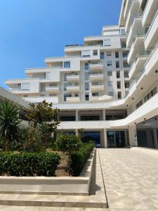 a large white building with a courtyard in front of it at Saranda Terraces Exclusive Appartment in Sarandë