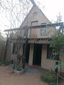 una casa con un balcón encima en Sabs Cottage, en Kasane