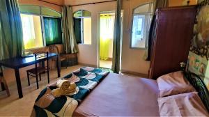 Schlafzimmer mit einem Bett, einem Tisch und Fenstern in der Unterkunft Golden Shell Residence in Trou dʼ Eau Douce
