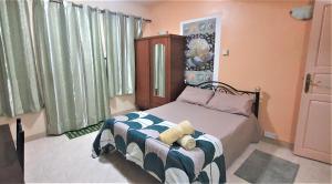 Un dormitorio con una cama con un osito de peluche encima. en Golden Shell Residence, en Trou d'Eau Douce