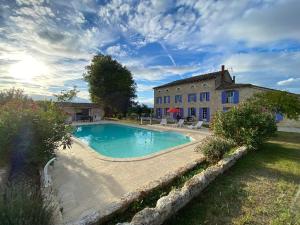 a large swimming pool in front of a building at Demeure De La Tour in Riocaud