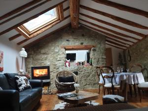 a living room with a fireplace and a stone wall at La Petite Chapelle in Font-Romeu