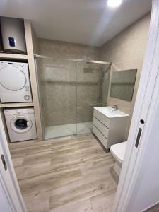 bagno con servizi igienici, lavandino e lavatrice di Apartamentos Montalvo Alessandri a Torremolinos