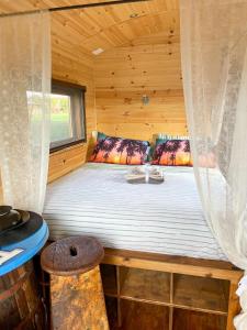 łóżko w drewnianym domku z oknem w obiekcie Romantic Gipsy w mieście Ivrea