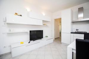 a kitchen with white cabinets and a flat screen tv at InnPisaRentals - Charme Pisa Toscana 2 in Pisa +11 photos