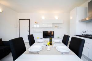 uma sala de jantar com uma mesa branca e cadeiras pretas em InnPisaRentals - Charme Pisa Toscana 2 em Pisa