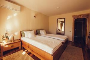 a bedroom with a large bed and a mirror at Denisa Boutique in Poiana Brasov