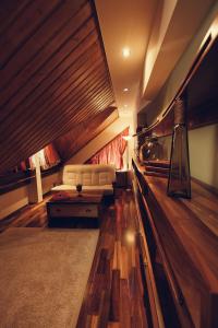 a living room with a white couch and wooden floors at Denisa Boutique in Poiana Brasov