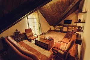 a living room with a couch and chairs and a television at Denisa Boutique in Poiana Brasov