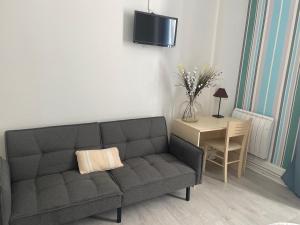 a living room with a couch and a table at Hotel Au Chapon Fin in Poitiers