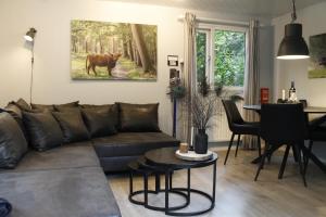 a living room with a couch and a table at VH Wellness Natuurhuisje Het spikkennust in Diever