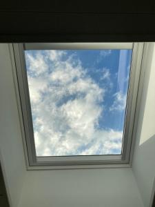 a window in a room with a cloudy sky at BiancoGelso b&b Vegan in Gardone Riviera