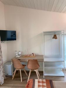 a desk and two chairs in a room at BiancoGelso b&b Vegan in Gardone Riviera