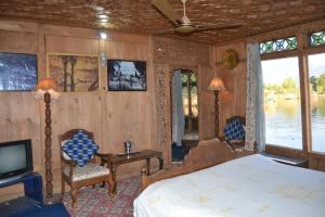 a bedroom with a bed and a tv in a room at Palace Heights Houseboats in Srinagar