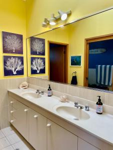 a bathroom with two sinks and a large mirror at Aqua Dolce Beach House in Copacabana