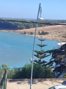 a street light with a pine tree in front of a lake at Villa Moulay bousselham in Moulay Bousselham