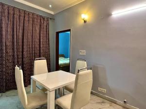 uma sala de jantar com uma mesa branca e cadeiras em Entire floor 2BHK with full Kitchen Near Medanta hospital em Gurgaon