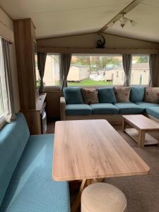 a living room with a table and a couch at Newquay Bay Porth Caravan - 6 berth in Newquay