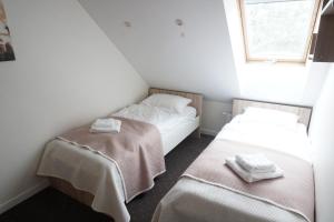 two beds in a small room with towels on them at Apartamenty Leśny Zakątek in Dziemiany