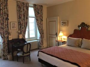 um quarto com uma cama, uma secretária e uma janela em La Résidence des Indes em La Rochelle