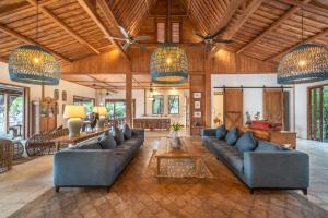 a living room with blue couches and chandeliers at Villa Pulau Cinta Boutique Suites in Gili Meno