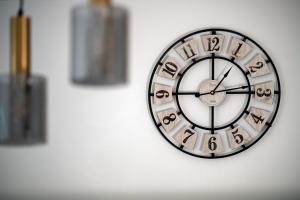 a clock with roman numerals on a wall at Easy Rent Apartments - Kosmos, 24h Check-in in Lublin